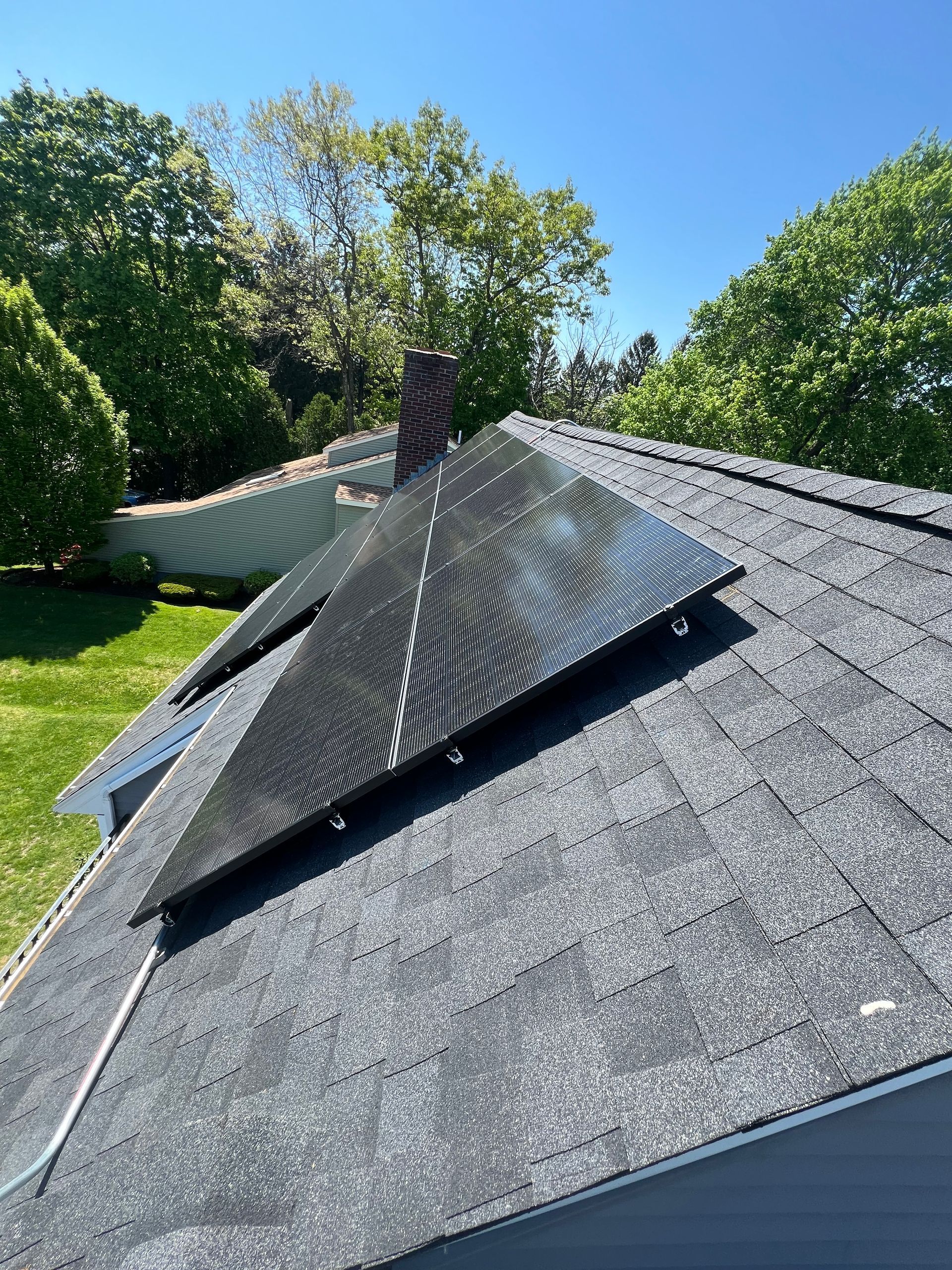 A solar panel is sitting on the roof of a house.