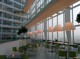 A large building with lots of windows and tables and chairs