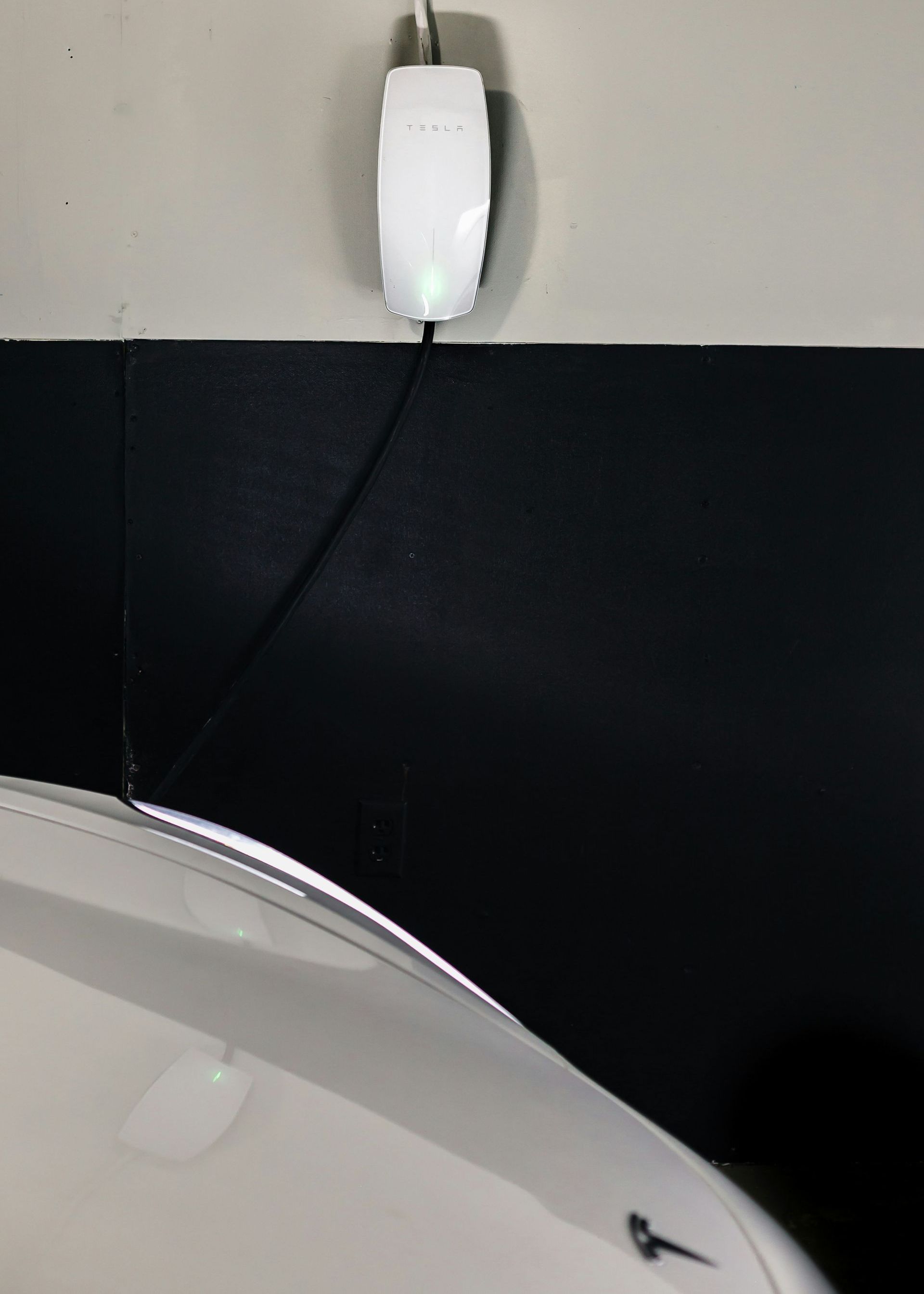 A white device is plugged into a black wall