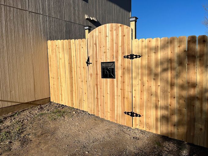 A wooden fence with a mailbox attached to it.
