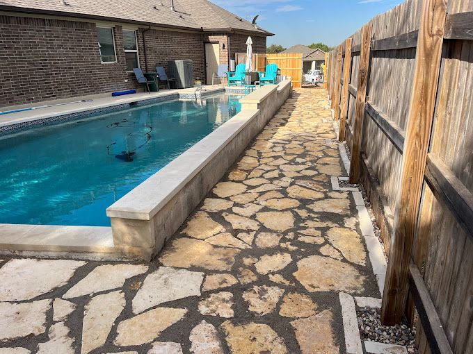 A stone walkway leading to a large swimming pool