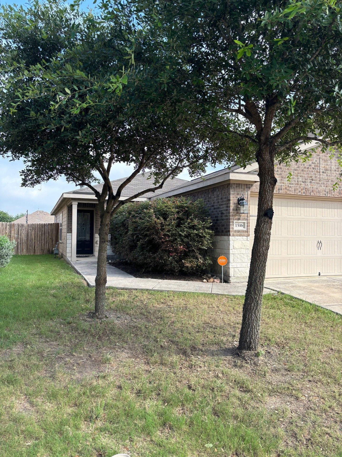 There are two trees in front of a house.