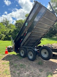 A dump truck is parked in a grassy field.