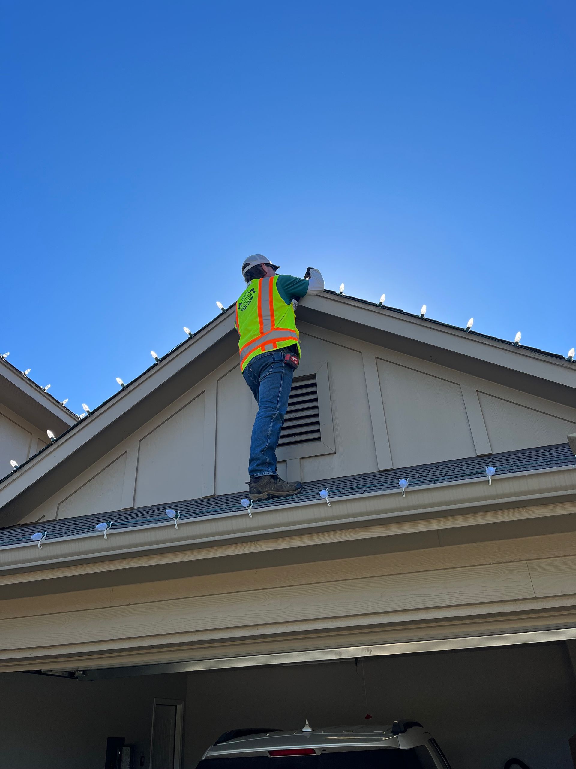 A man is standing on the roof of a house.
