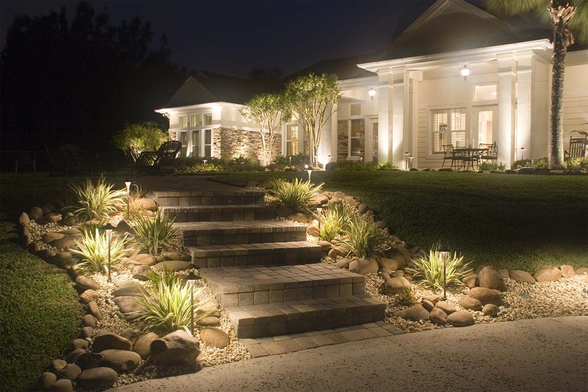 A house with stairs leading up to it is lit up at night