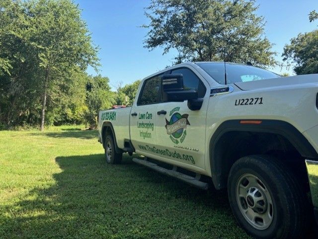 A white truck is parked in a grassy field.