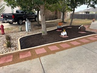 Front yard with mulch, brick pavers, trees, truck, and decorative rabbit statues.