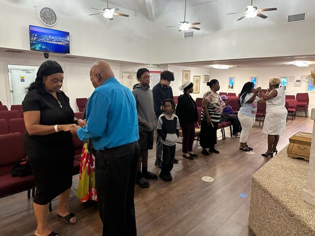 A group of people are standing in a line in a church.