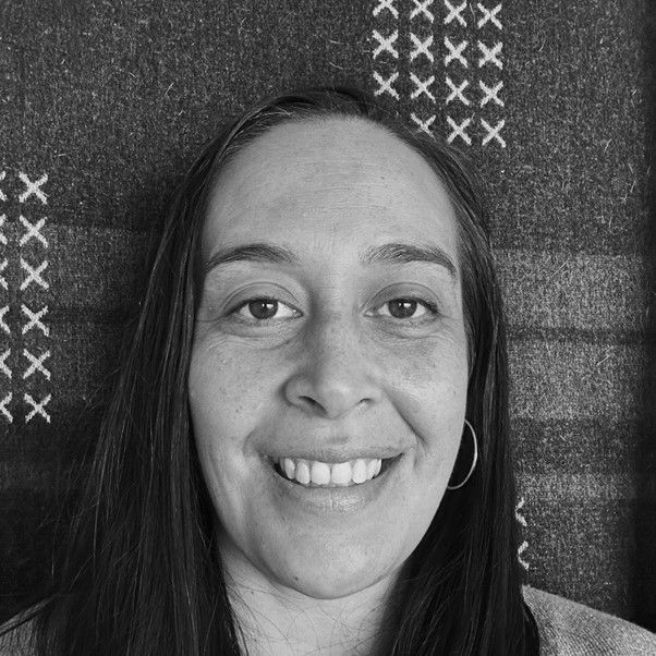 A woman is smiling in a black and white photo.