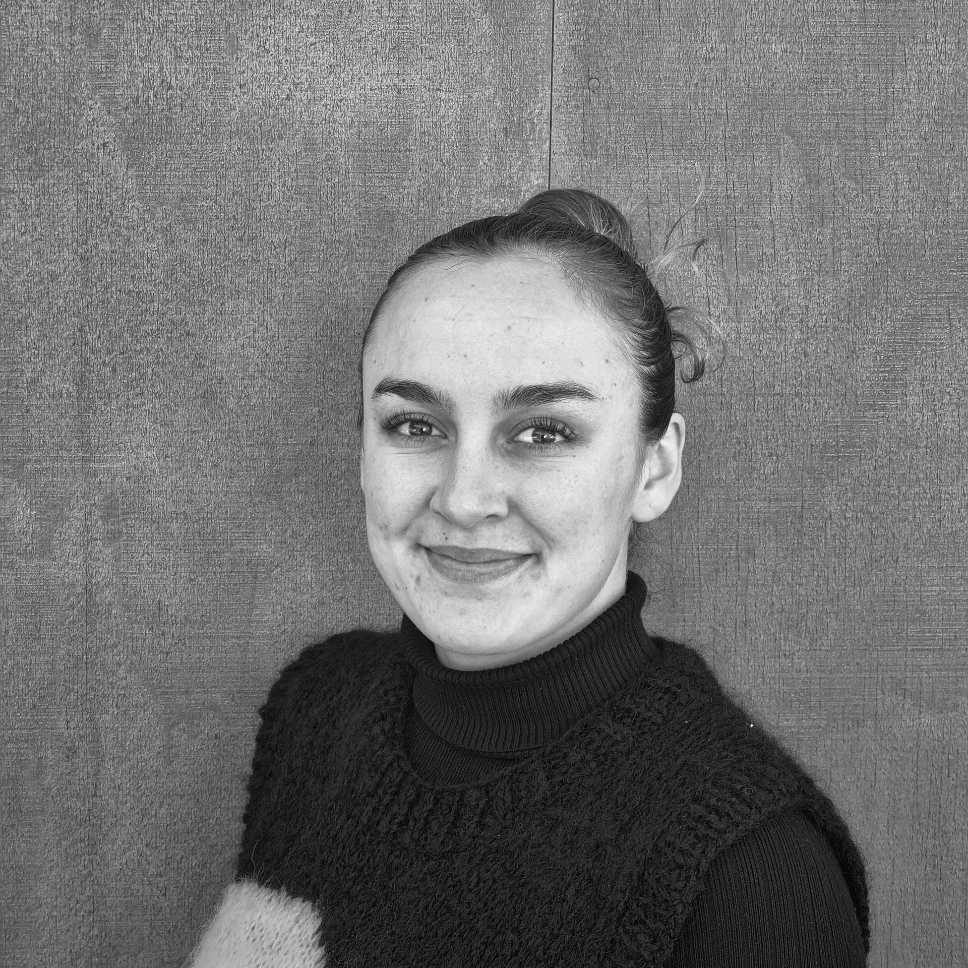 A black and white photo of a woman smiling. 