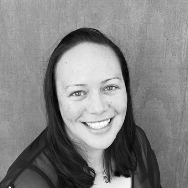 A woman is smiling in a black and white photo.