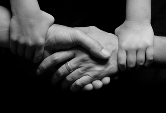 A man and a child are shaking hands in a black and white photo