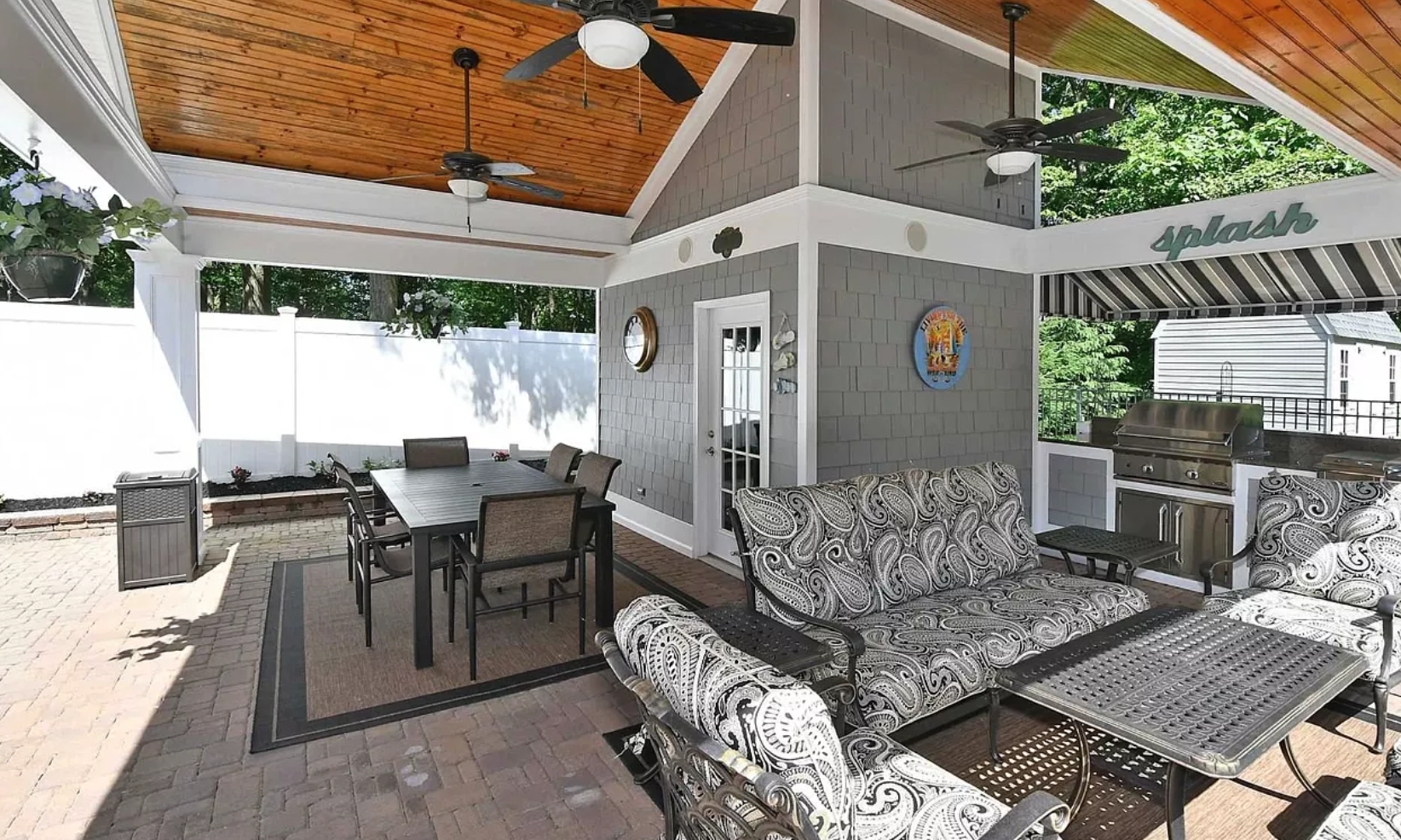 A patio with a table and chairs and a ceiling fan