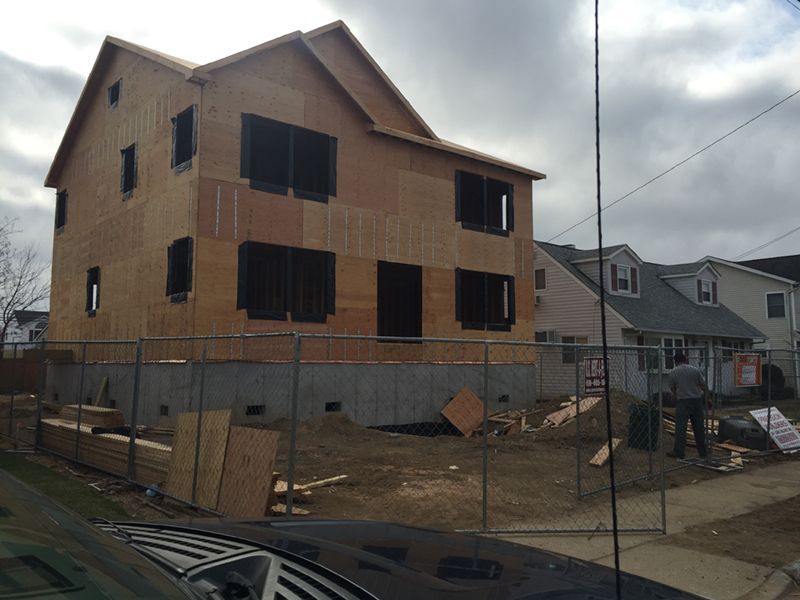 A car is parked in front of a house under construction