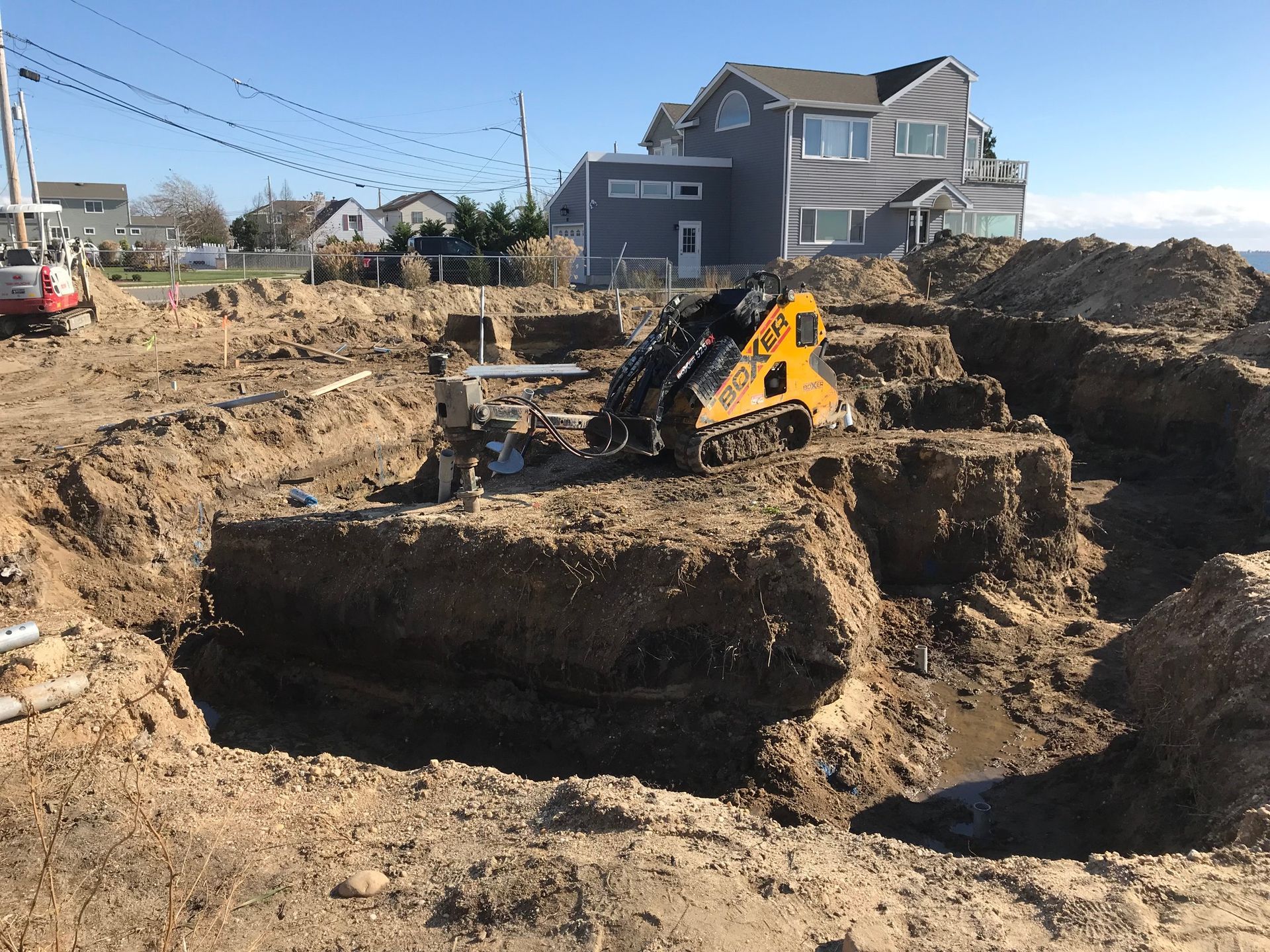 A construction site with a house in the background