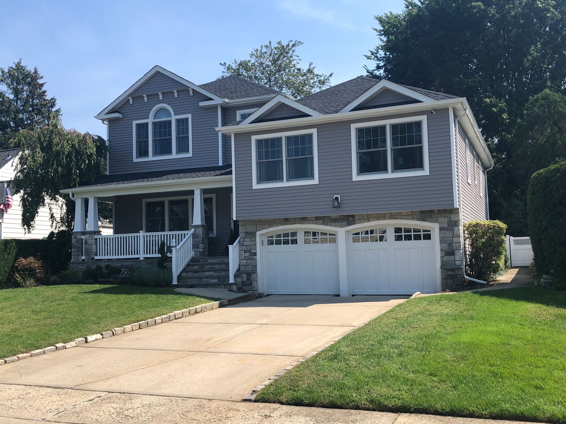 A large gray house with a white garage door