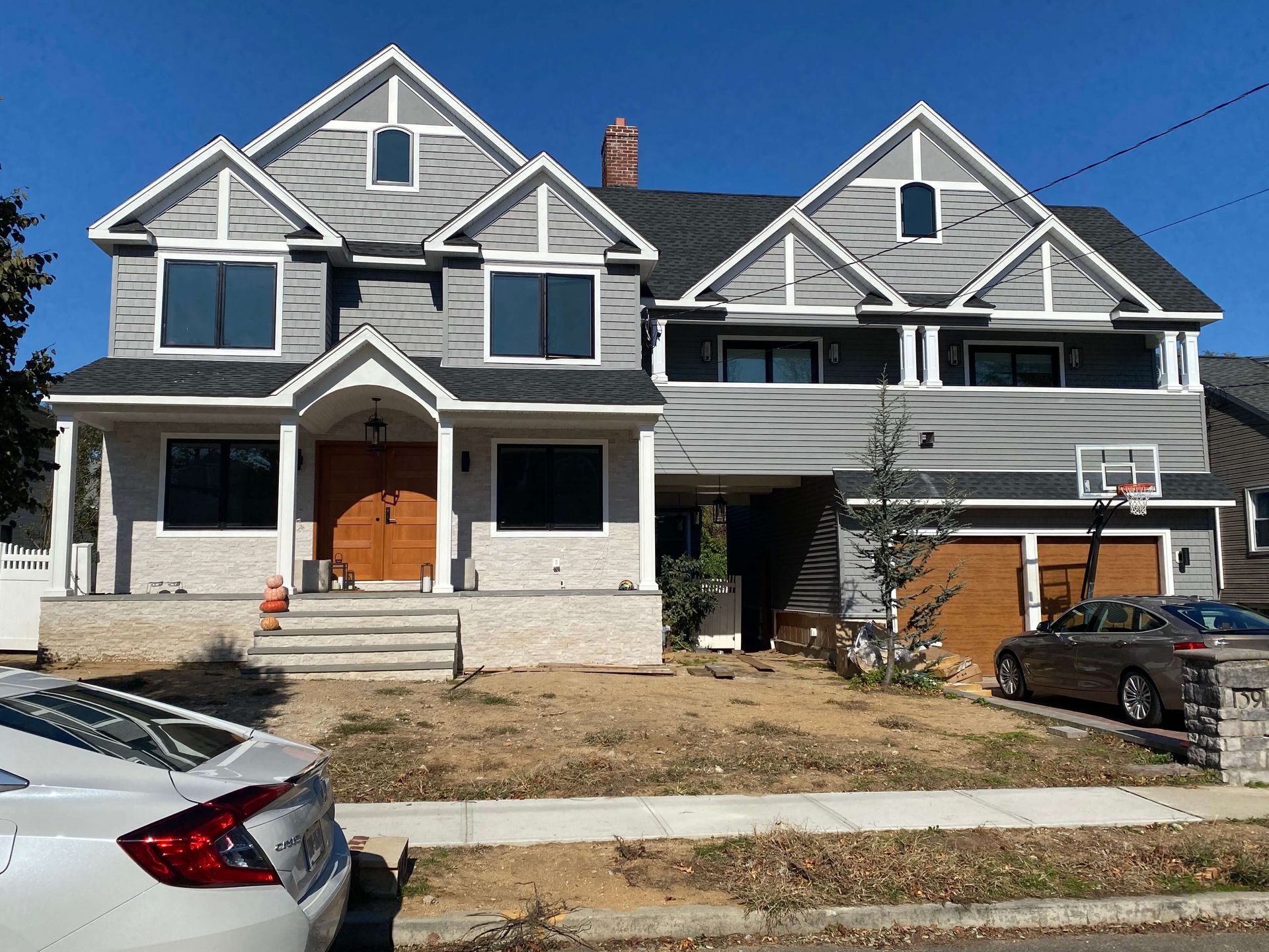A large house with two cars parked in front of it