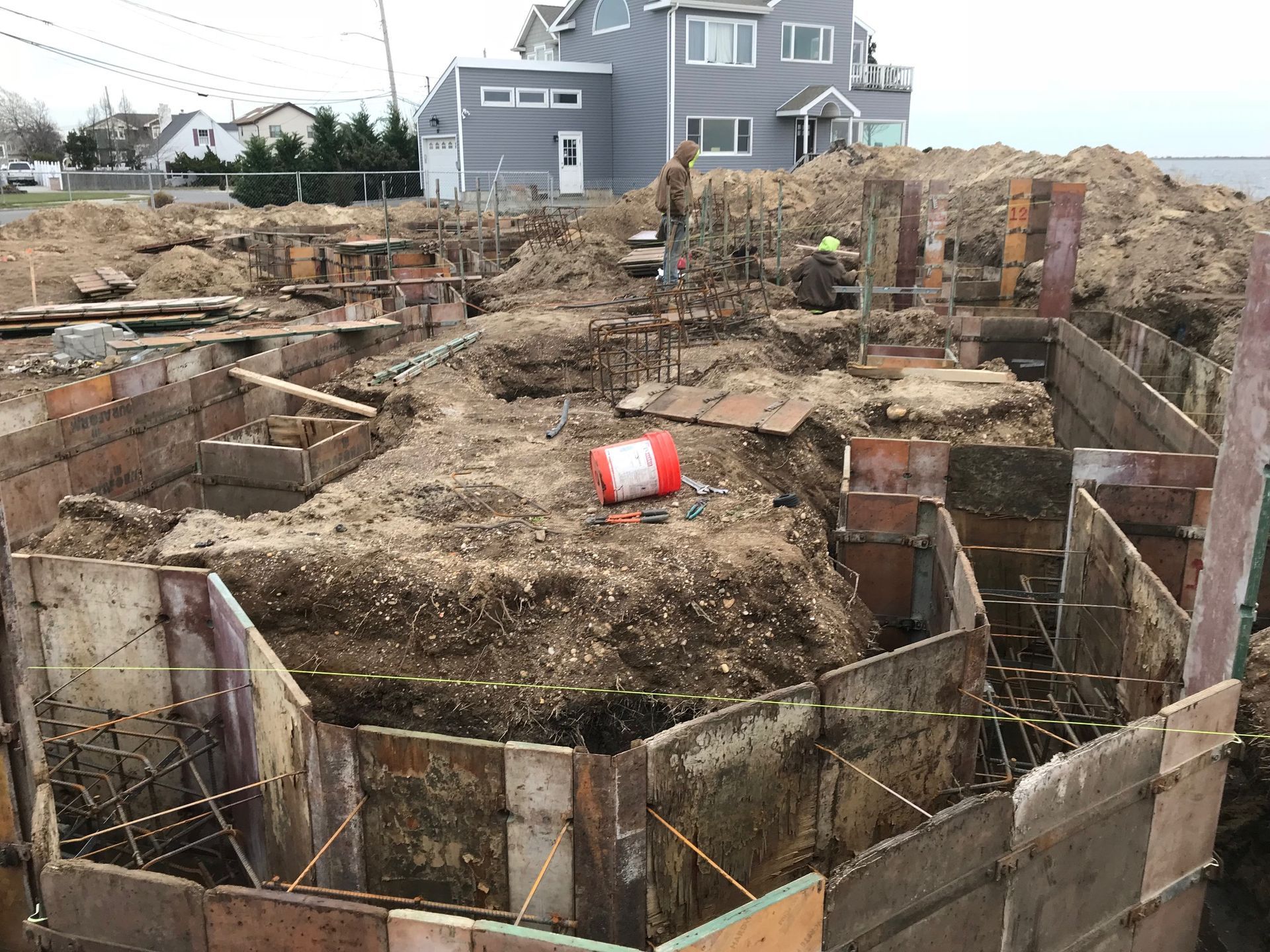 A construction site with a large house in the background.