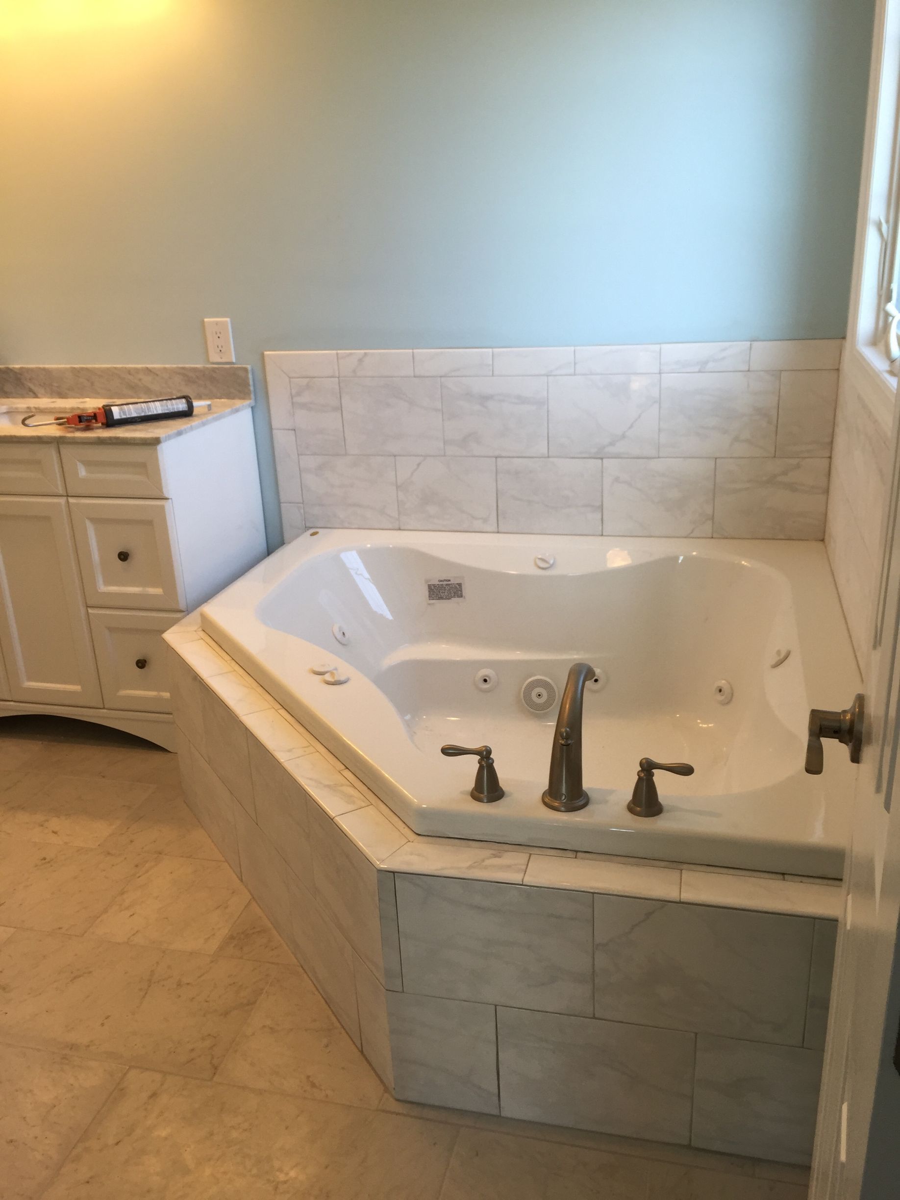 A bathroom with a jacuzzi tub and a sink.