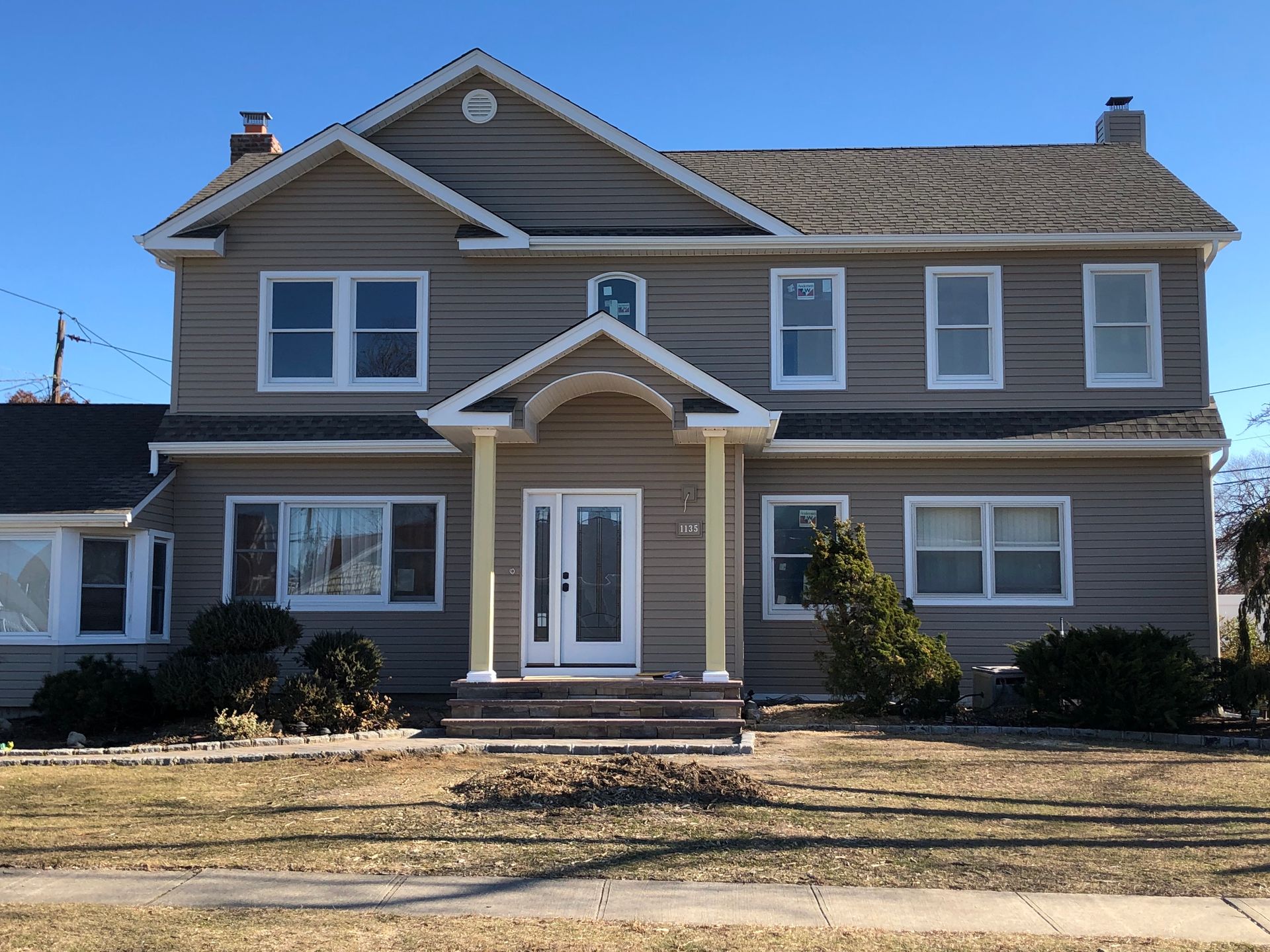 A large house with a blue sky in the background