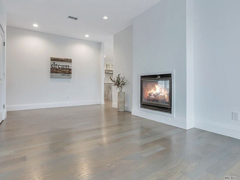 A living room with hardwood floors and a fireplace.
