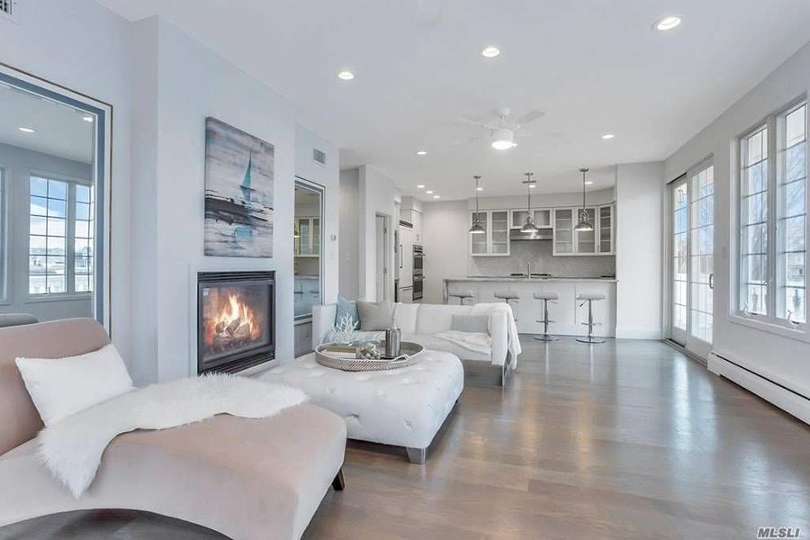 A living room with a fireplace , couch , chair and ottoman.