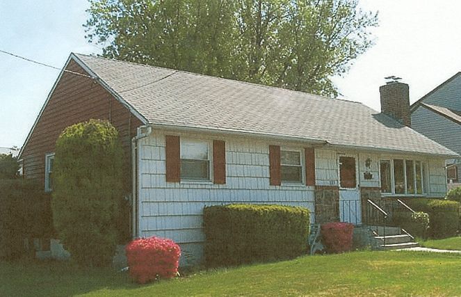 A small house with a red roof and white siding