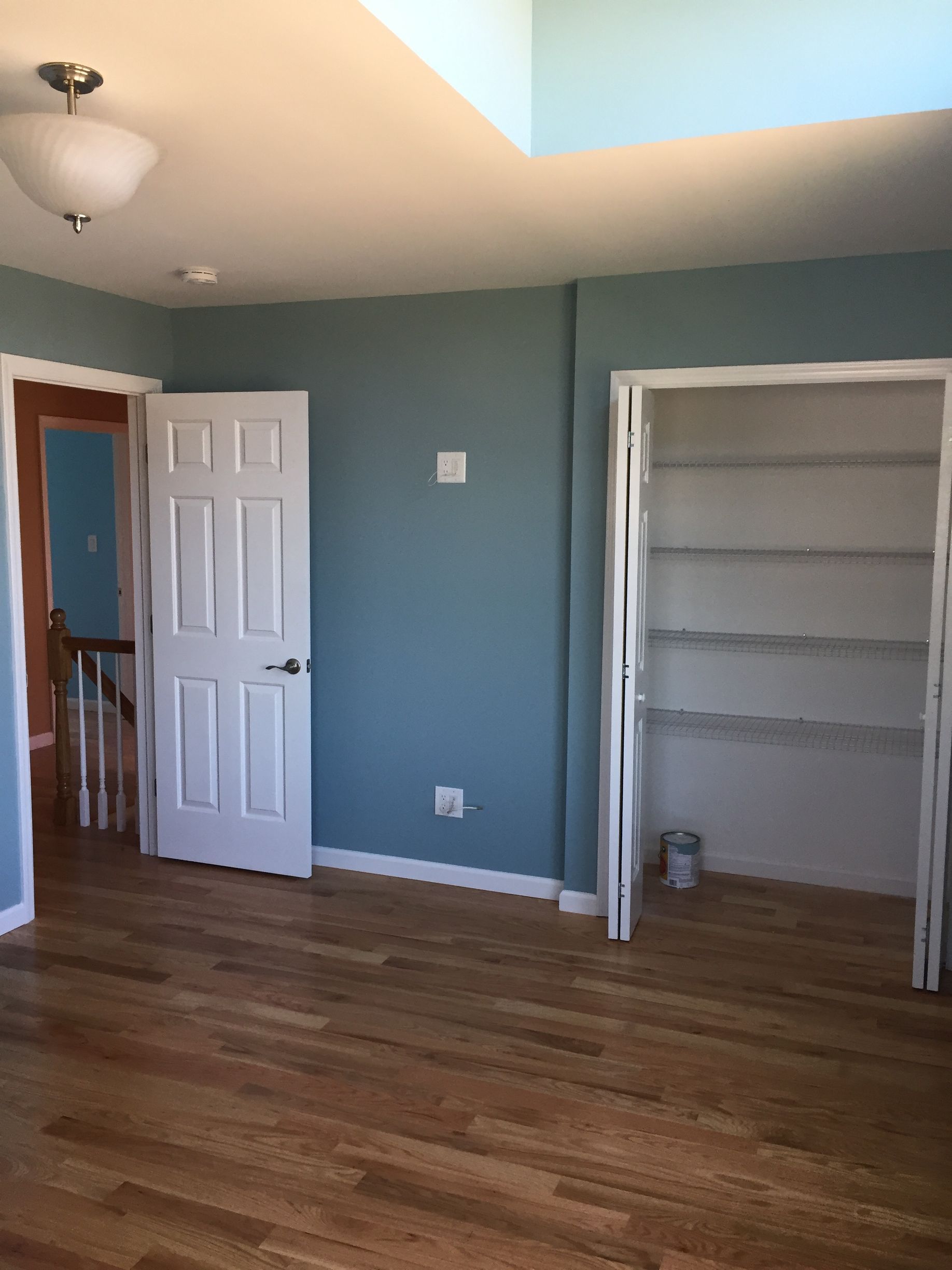 An empty room with hardwood floors and blue walls