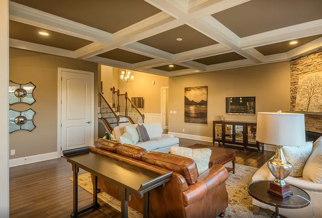 A living room filled with furniture and a coffered ceiling.