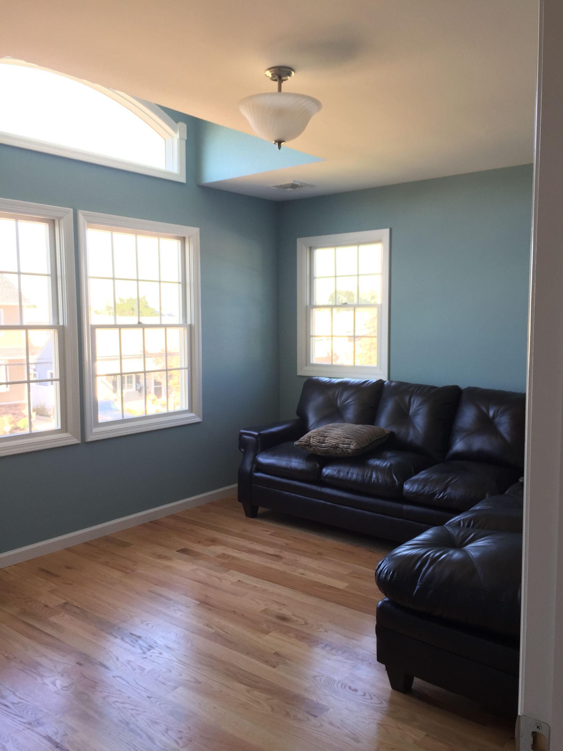 A living room with a couch and two windows