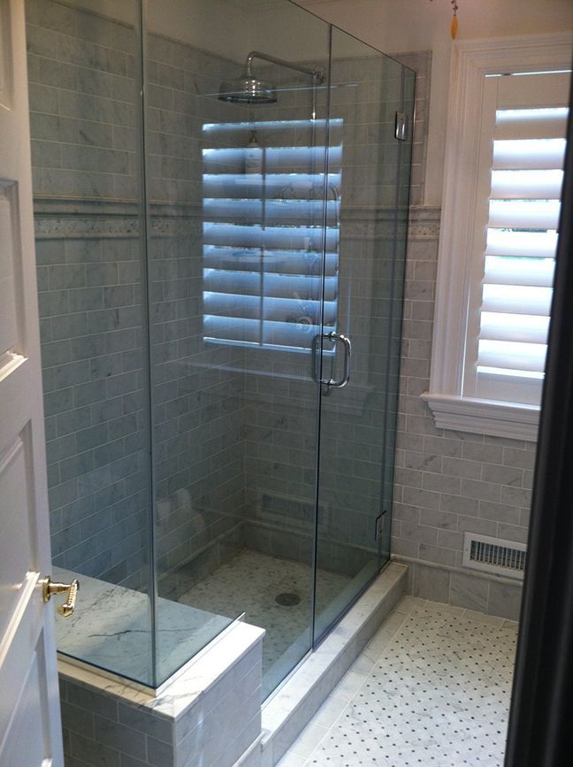 A bathroom with a walk in shower and a window