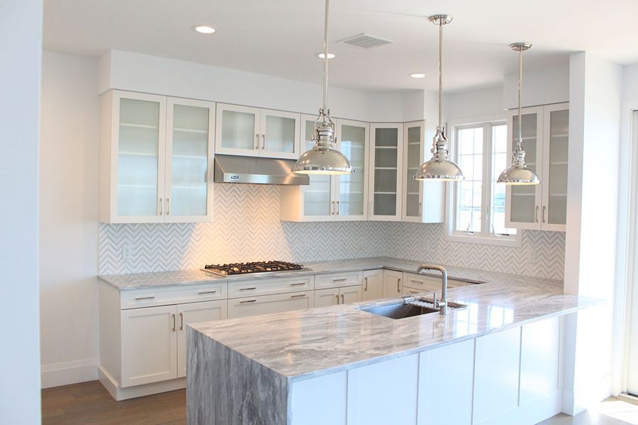 A kitchen with white cabinets and granite counter tops