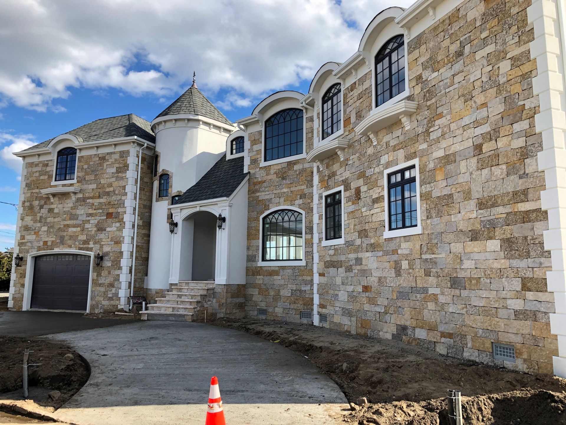 A large stone house with a lot of windows is being built.