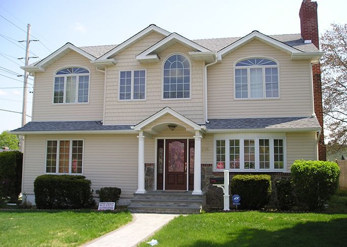 A large house with a lot of windows and a porch