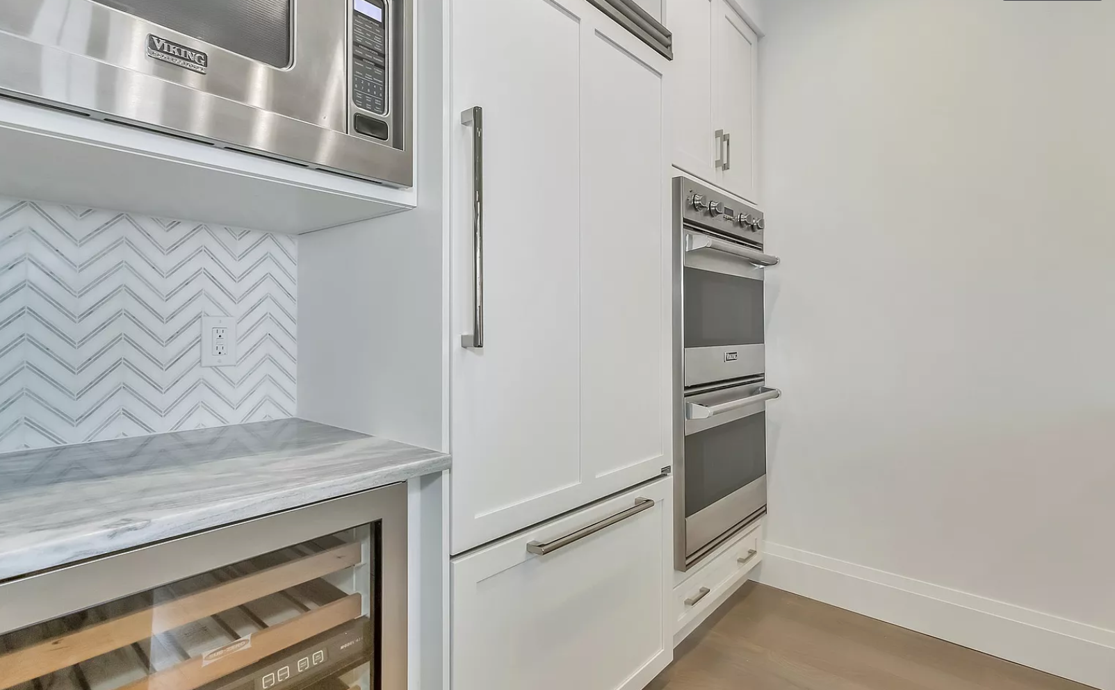 A kitchen with stainless steel appliances and a wine cooler.