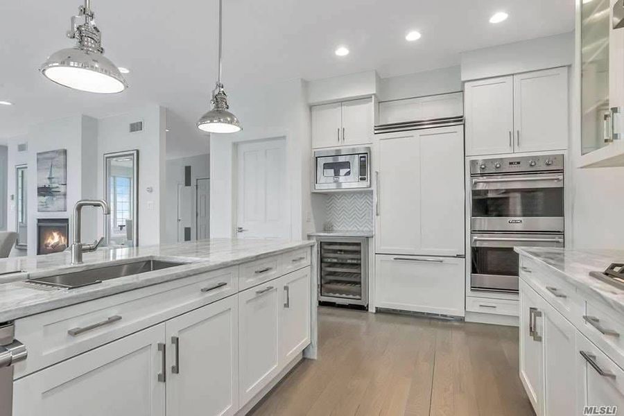 A kitchen with white cabinets and stainless steel appliances.