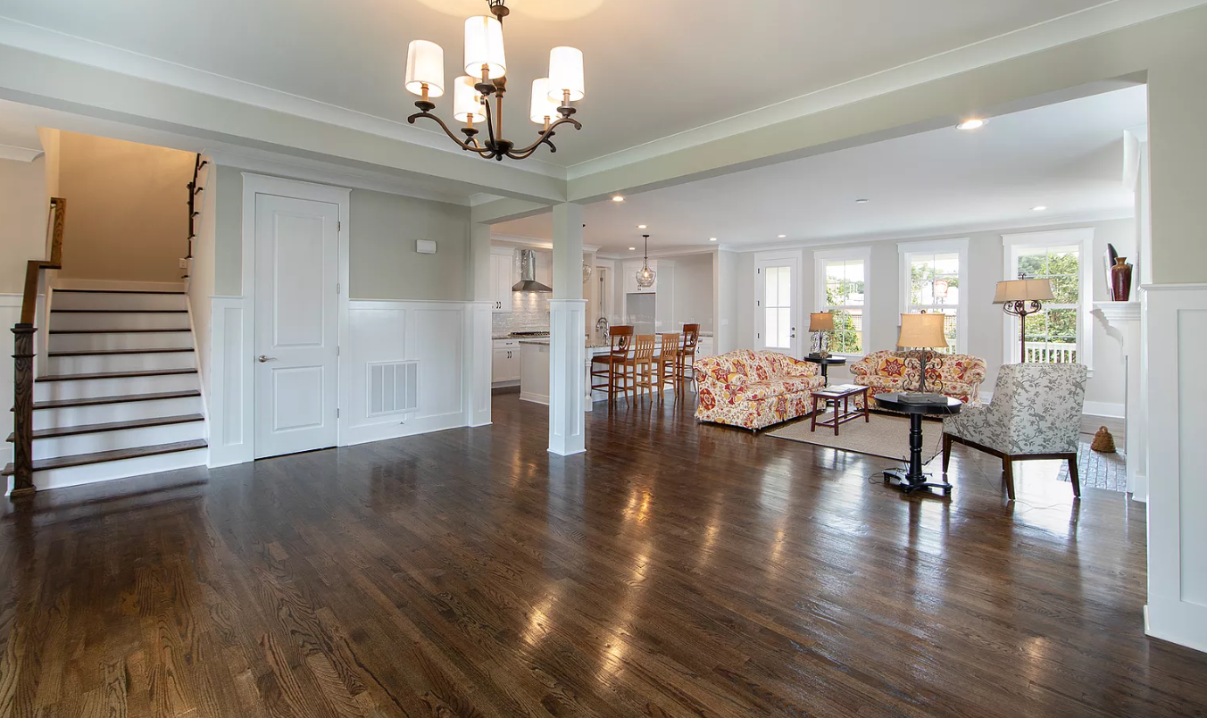 A large living room with hardwood floors and a chandelier.