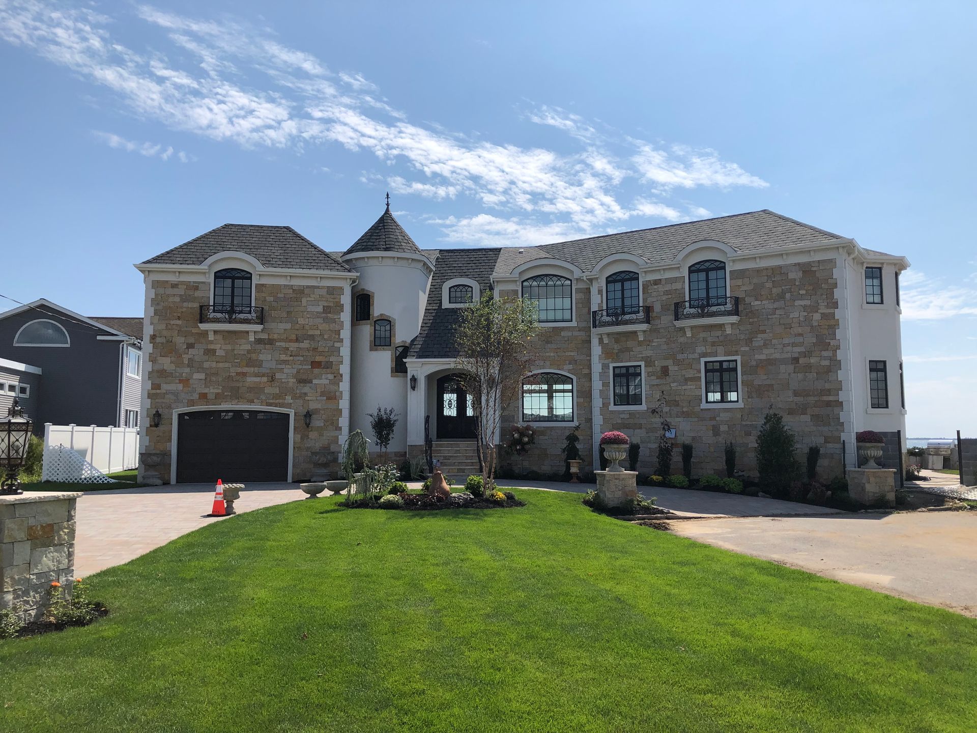A large stone house with a lush green lawn in front of it.