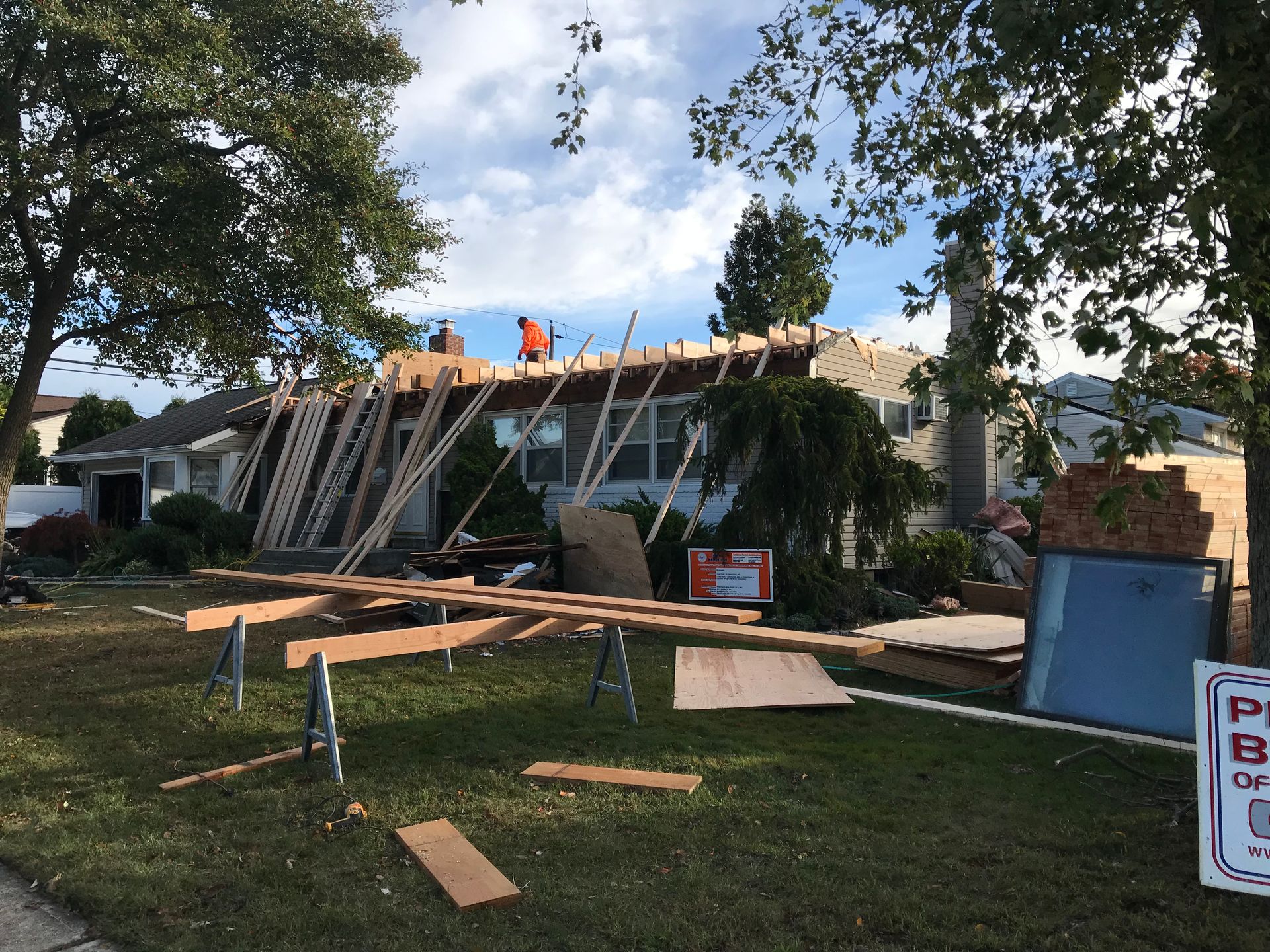 A house is being remodeled with a sign in the foreground.