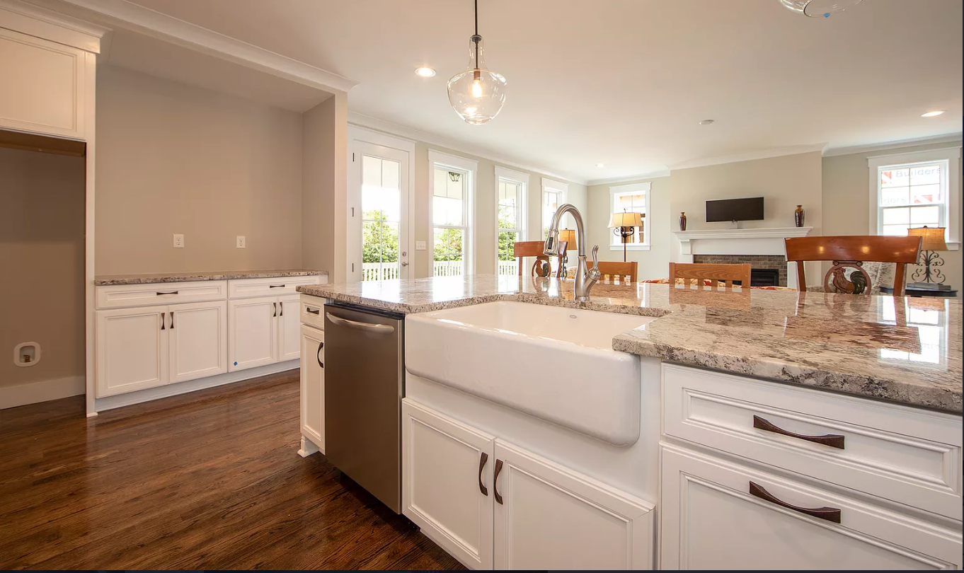 A kitchen with a large sink and granite counter tops