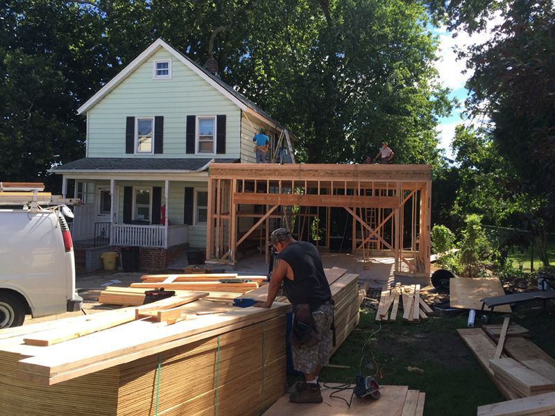 A man is working in front of a house under construction