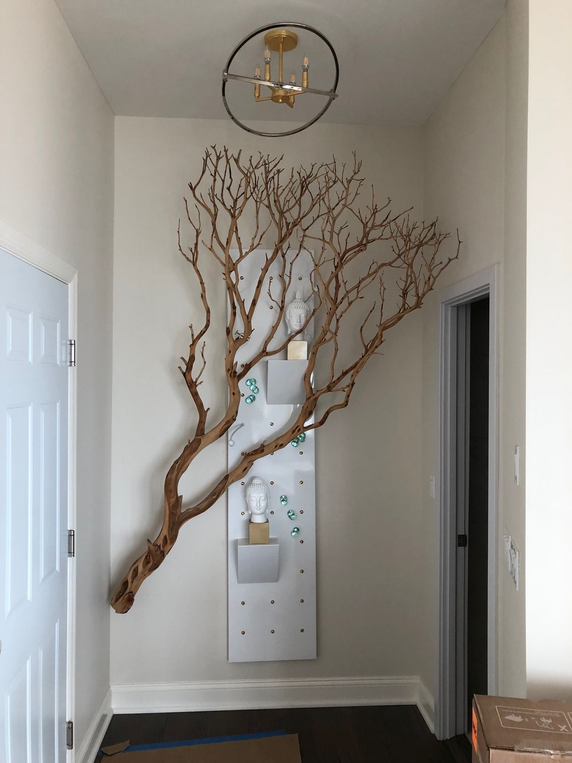 A large tree branch is hanging on a wall in a hallway.