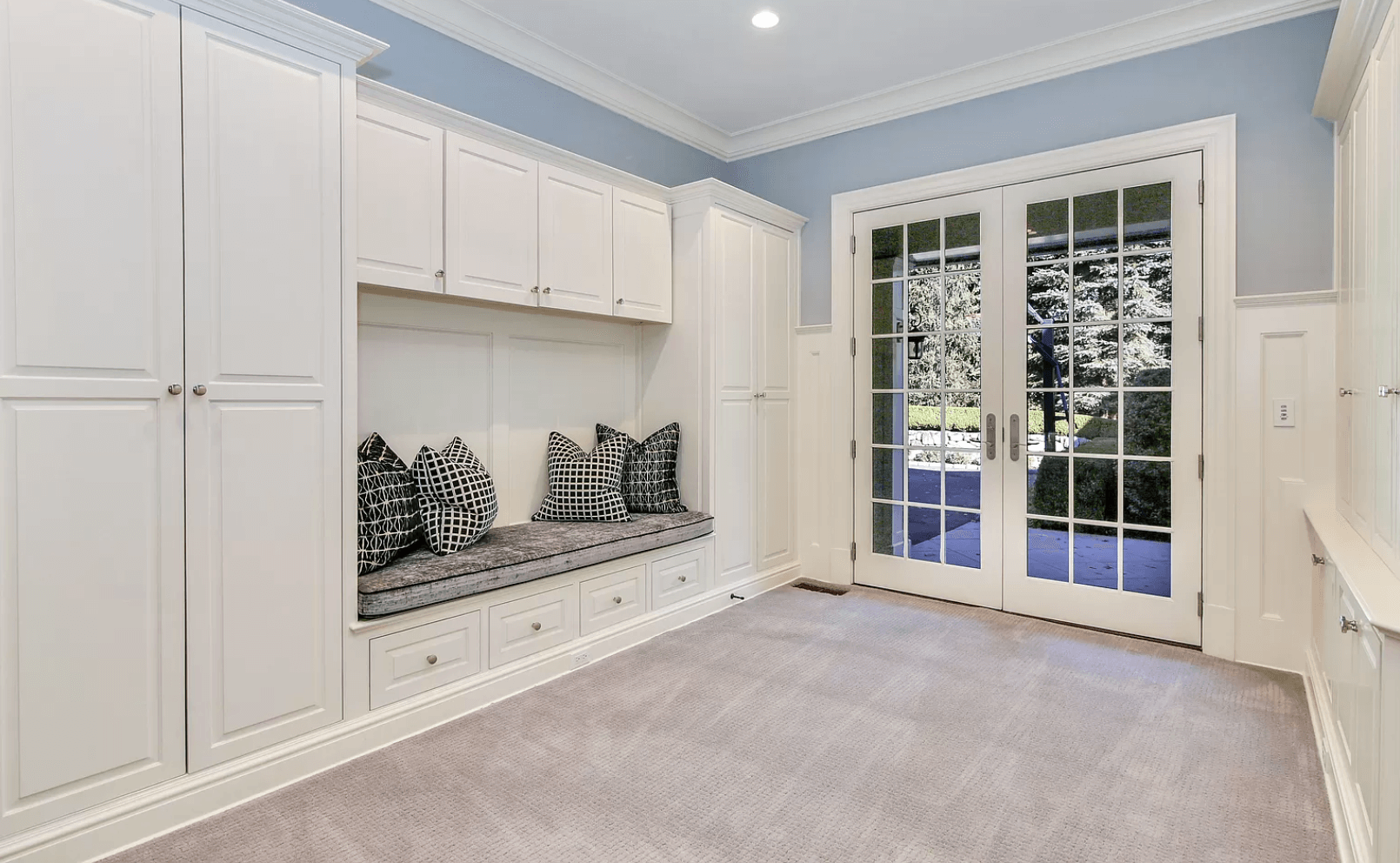 A room with a bench and sliding glass doors leading to a patio.