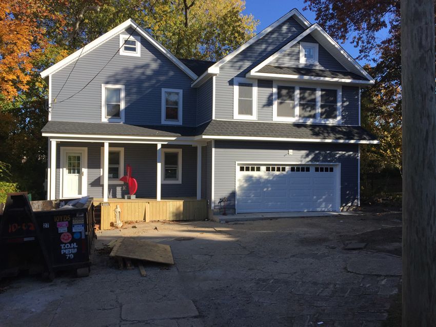 A large blue house with a white garage door