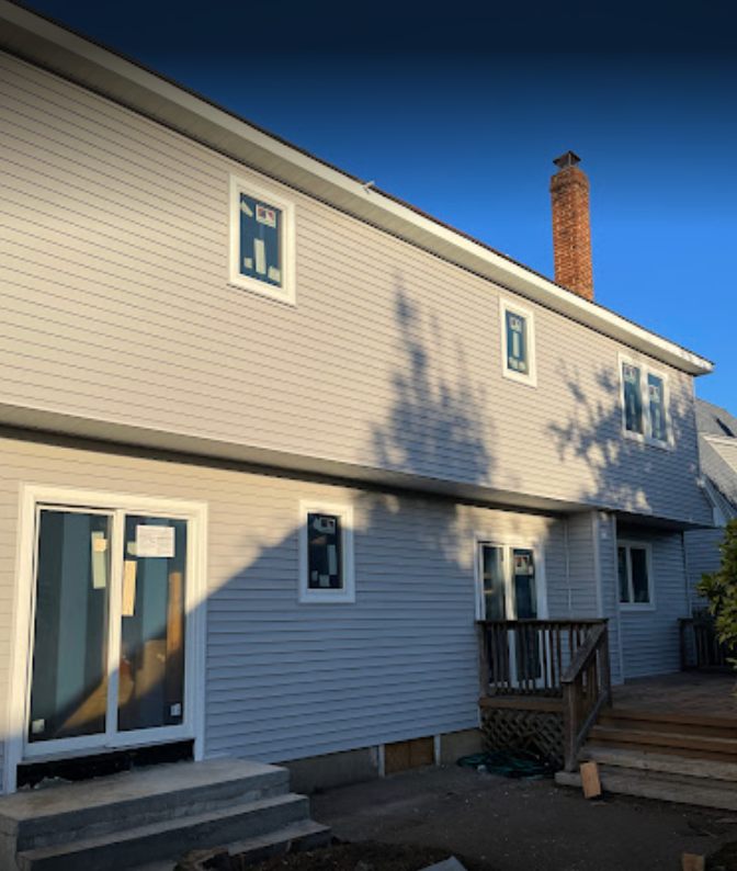 A white house with a brick chimney on top of it