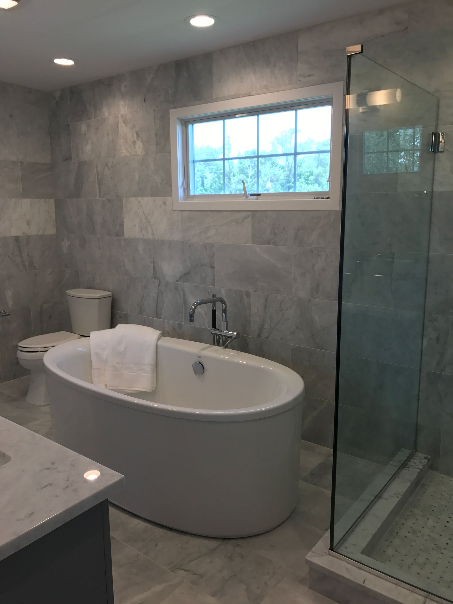 A bathroom with a tub a toilet and a shower