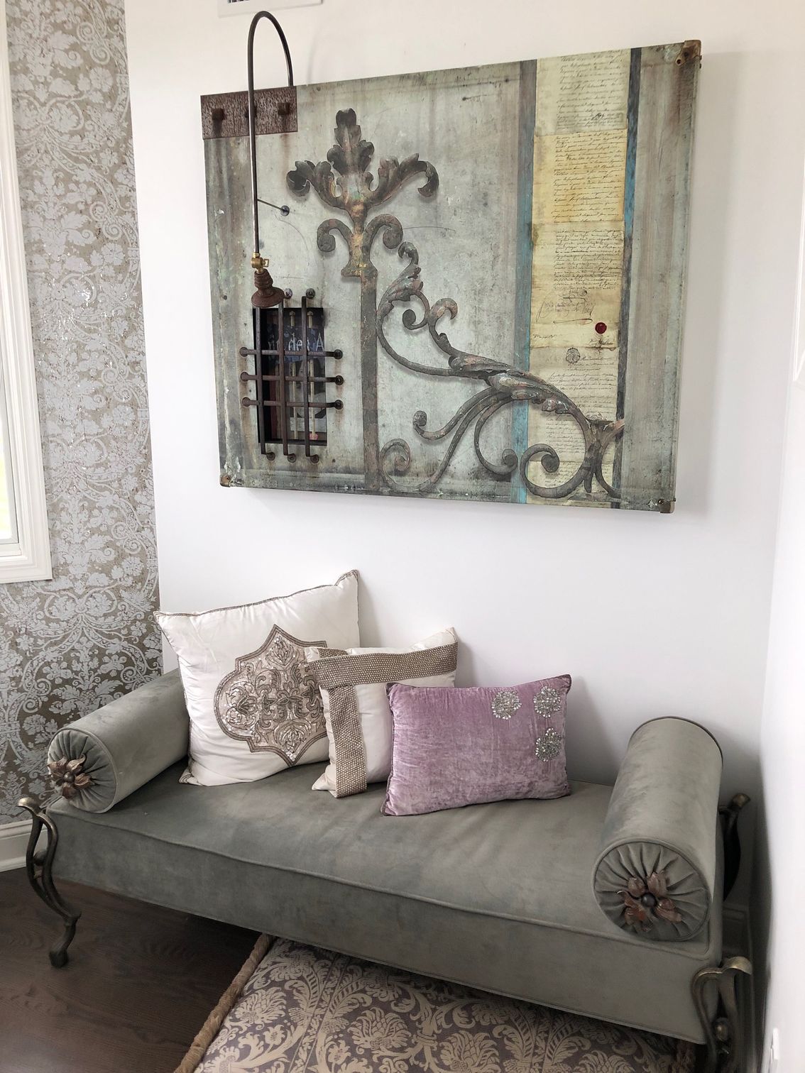 A couch with pillows and a painting on the wall above it.