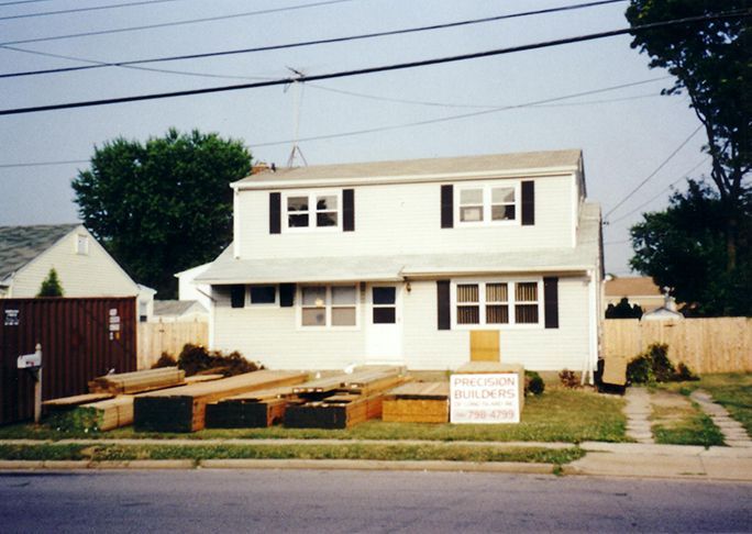 A white house with a sign in front of it that says ' new home builders '