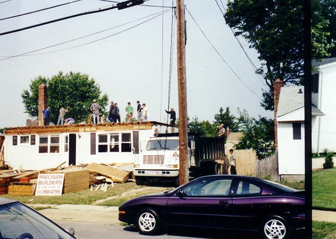 A purple car is parked in front of a building under construction