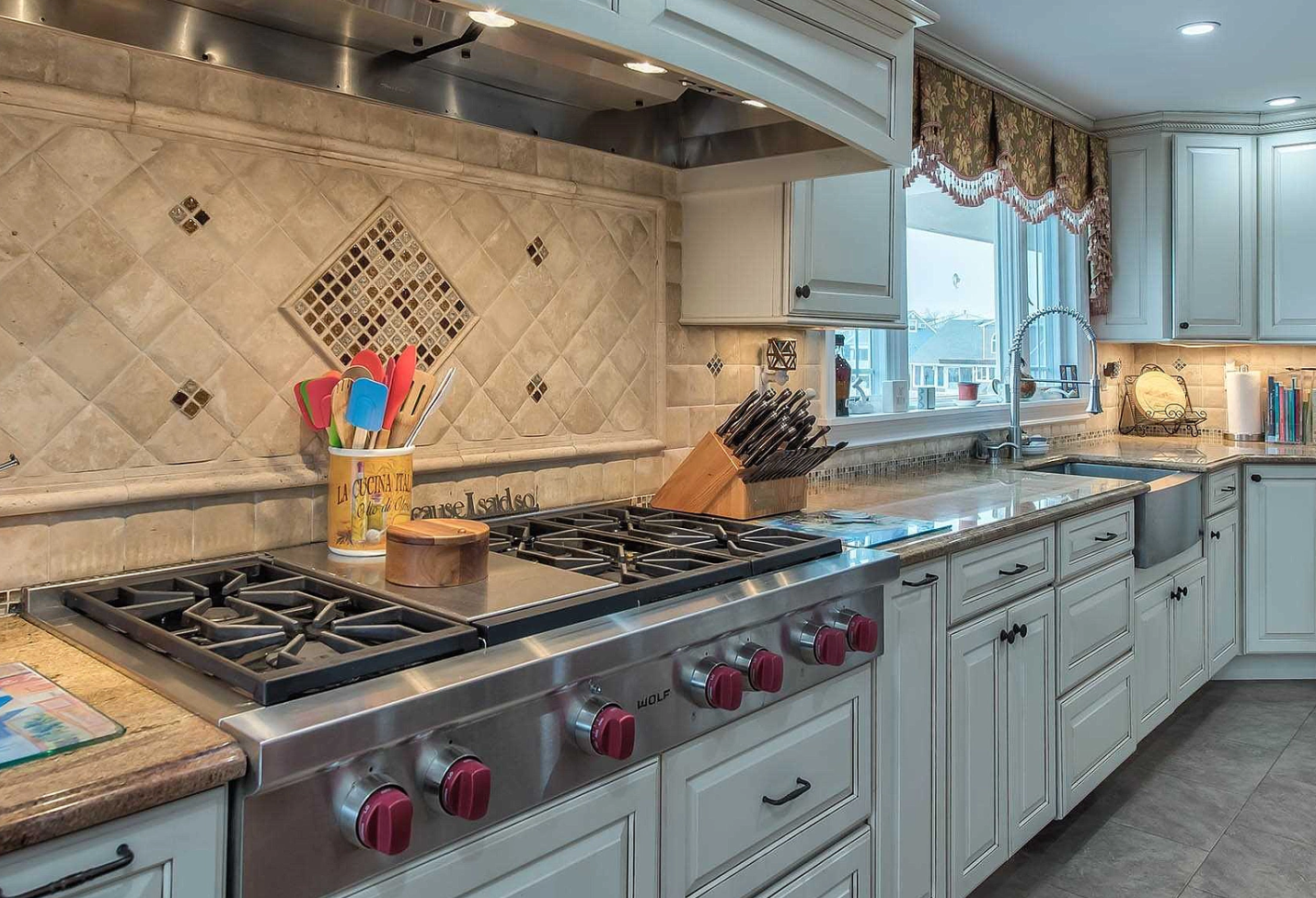 A kitchen with stainless steel appliances and white cabinets.